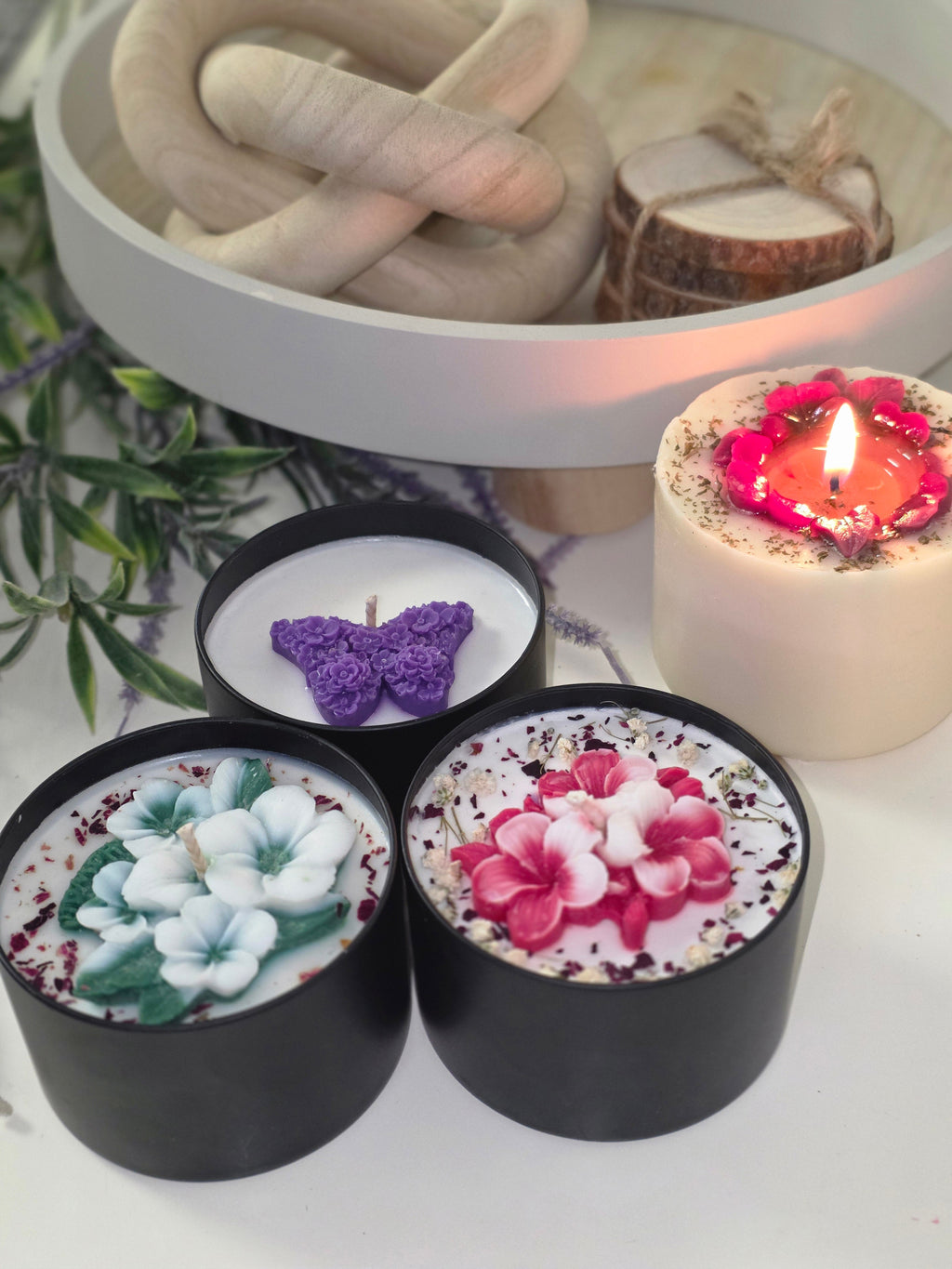 Three sculptured botanical soy candles in black tins