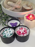 Three sculptured botanical soy candles in black tins