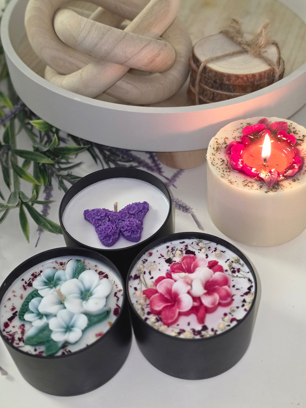 Botanical candles with lit candle in background